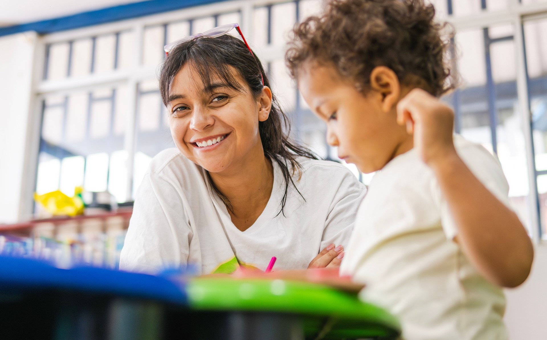 Happy teacher smiling with a child in preschool