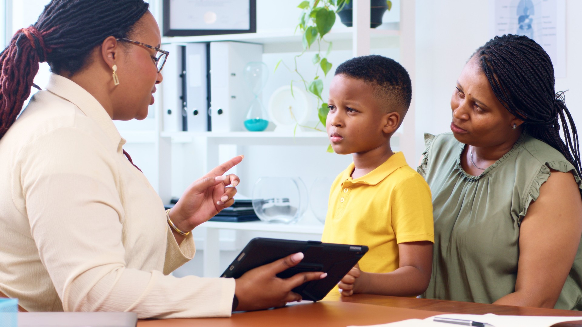 Doctor Consults Concerned Mother and Child in Modern Medical Office Environment