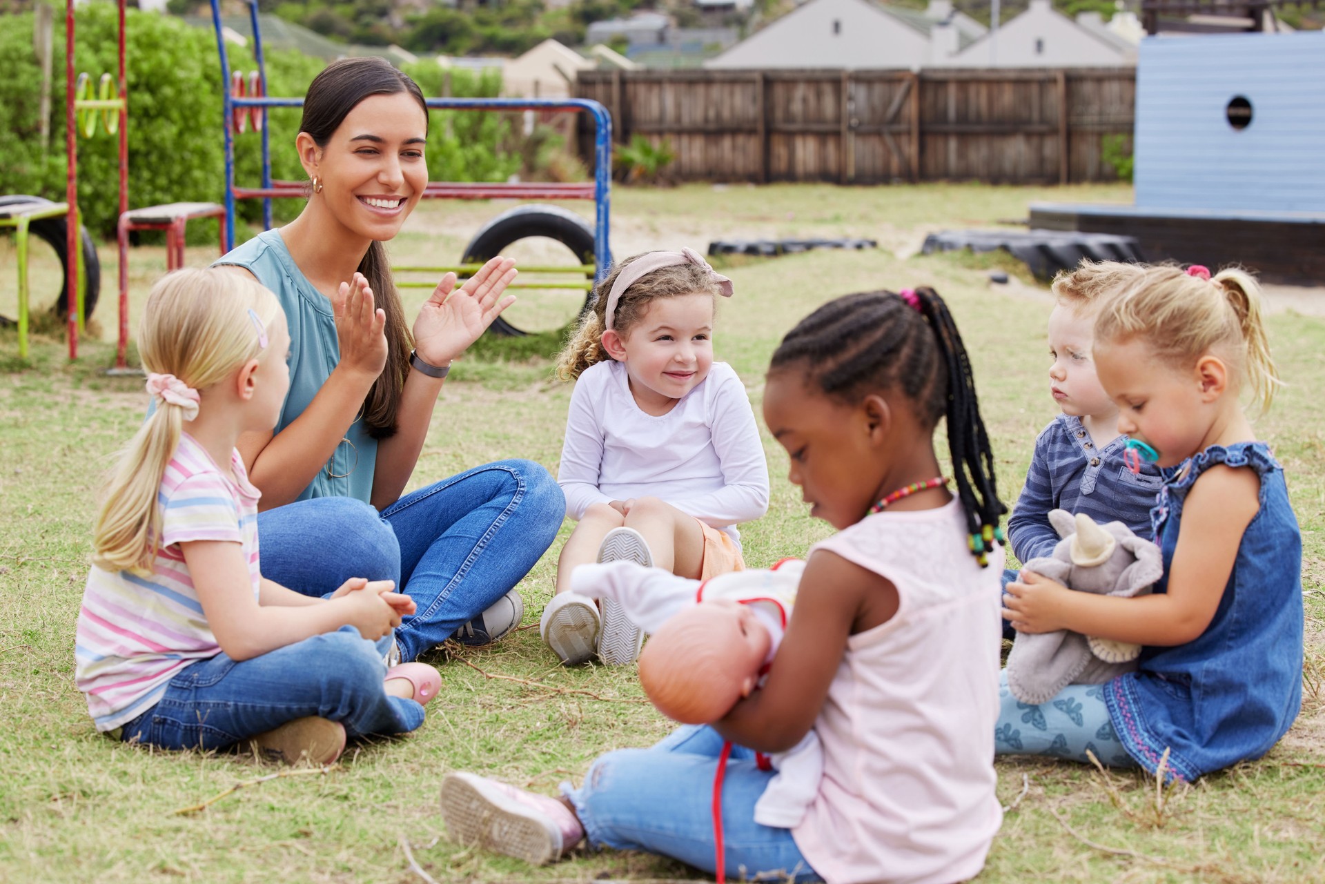 Shot of a teacher spending time outside with preschool children