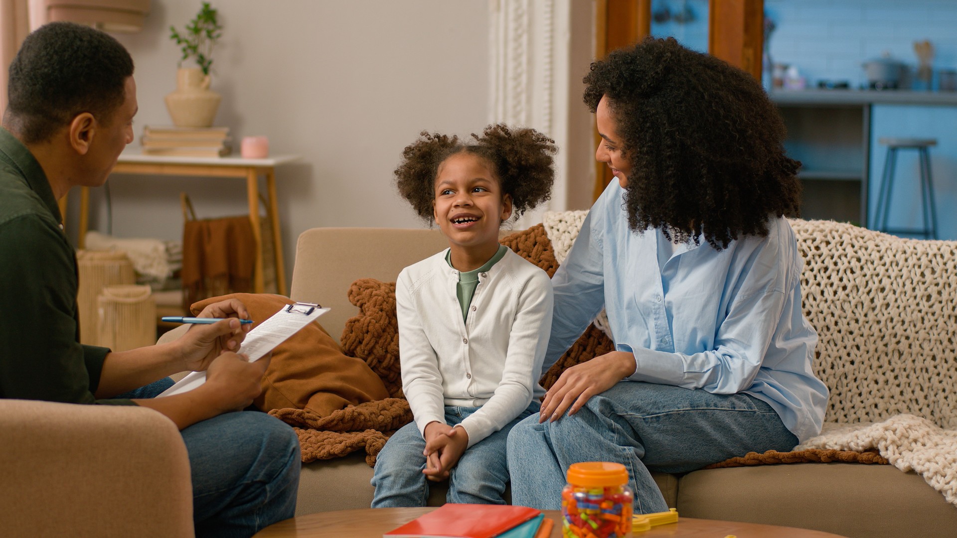African American woman man child little girl mother daughter together psychologist appointment home conversation communicate talking write notes doctor family good relationship mutual understanding